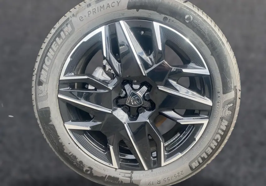 Gros plan sur la jante alu noire et argentée d’un Peugeot 3008 1.2 hybrid 145 allure e-dcs6 bleu obsession.