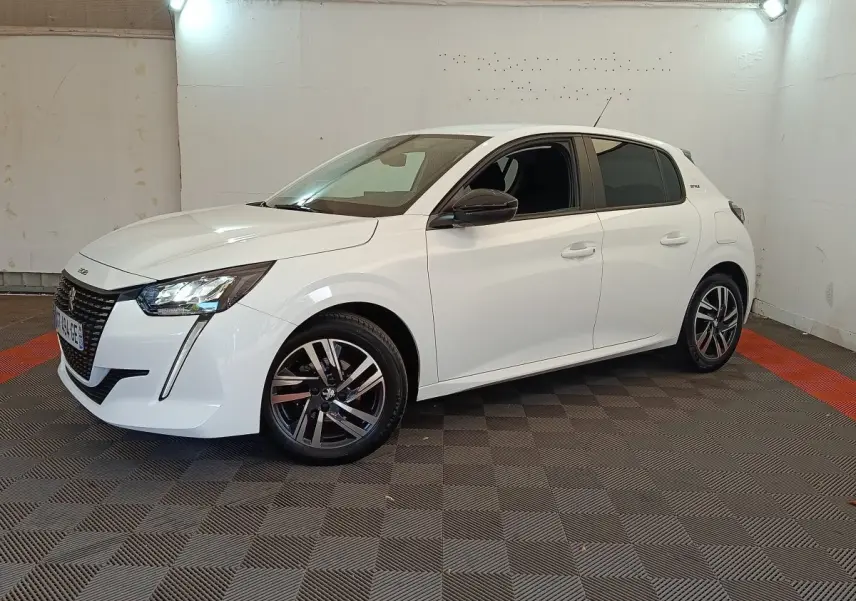 Peugeot 208 PureTech 75 S&S Style blanc vue 3/4 avant droit dans un espace intérieur éclairé.