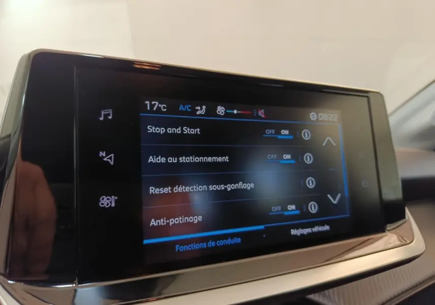 Écran tactile central de la Peugeot 208 PureTech 75 Style affichant les options d'aide à la conduite, vue intérieure.