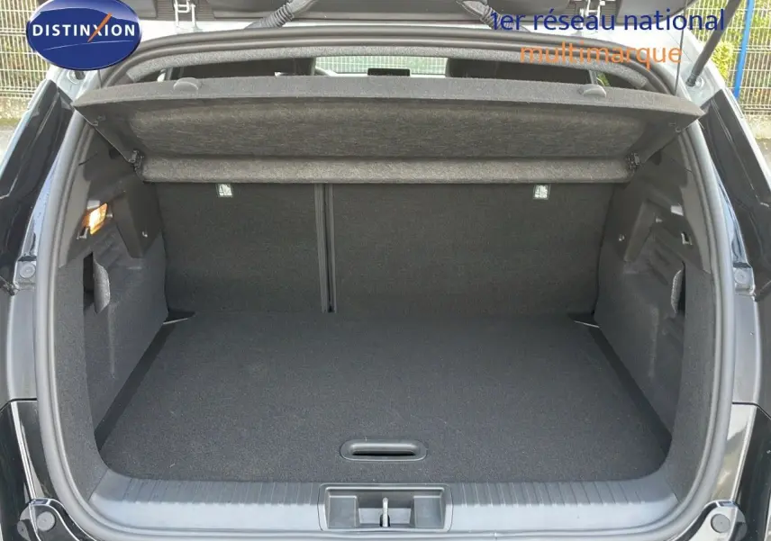 Coffre ouvert vu de l'arrière du Renault Captur noir étoile métal avec toit gris, espace de chargement vide et propre.