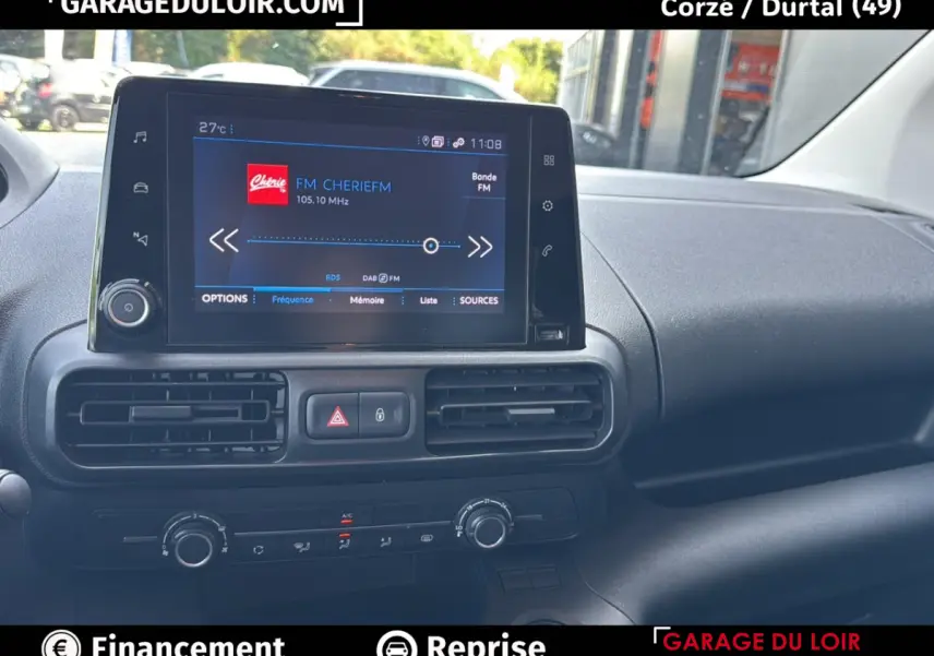 Vue intérieure du tableau de bord du Peugeot Rifter 2024, écran tactile central affichant une radio FM.