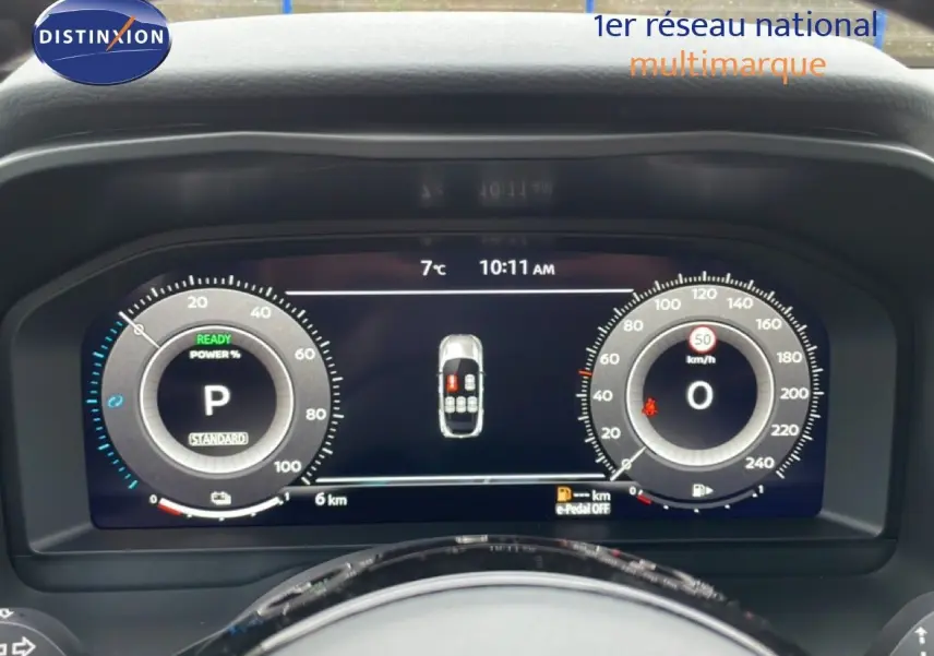 Tableau de bord numérique du Nissan Qashqai blanc nacré, affichant vitesse, température et état du véhicule.