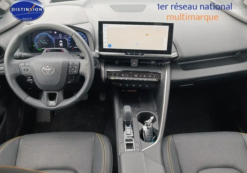 Vue intérieure frontale du Toyota C-HR hybride 2025 avec tableau de bord numérique et écran tactile central.