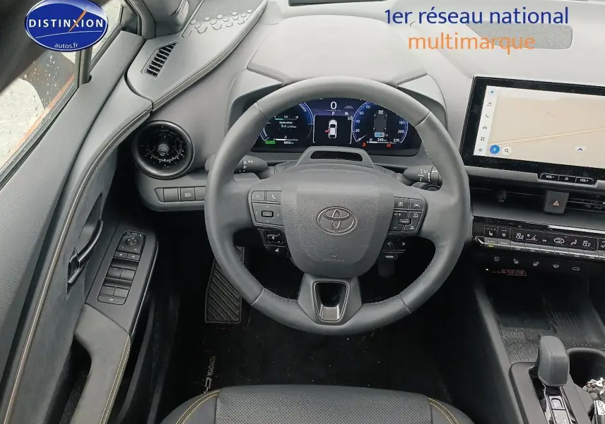 Vue intérieure centrée sur le volant et tableau de bord du Toyota C-HR hybride 2025, finition or/noir.