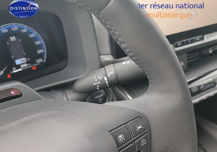 Gros plan sur le volant multifonction noir et le tableau de bord numérique du Toyota C-HR hybride 2025.