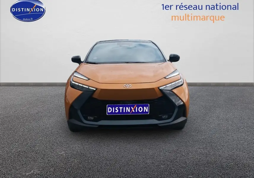 Vue frontale du Toyota C-HR 2.0 hybride 2025 en or et noir avec calandre noire et phares LED distinctifs.