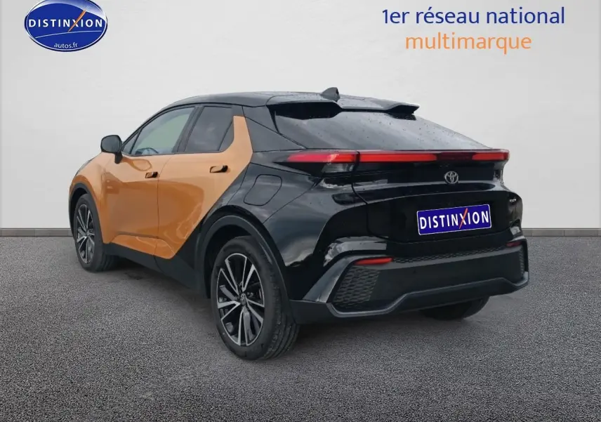 Toyota C-HR hybride 2025 or et noir, vue 3/4 arrière droit, avec toit et jantes noires distinctives.