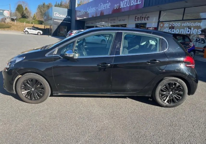Profil côté gauche d'une Peugeot 208 noire de 2017, avec jantes noires et vitres légèrement teintées, stationnée en extérieur.