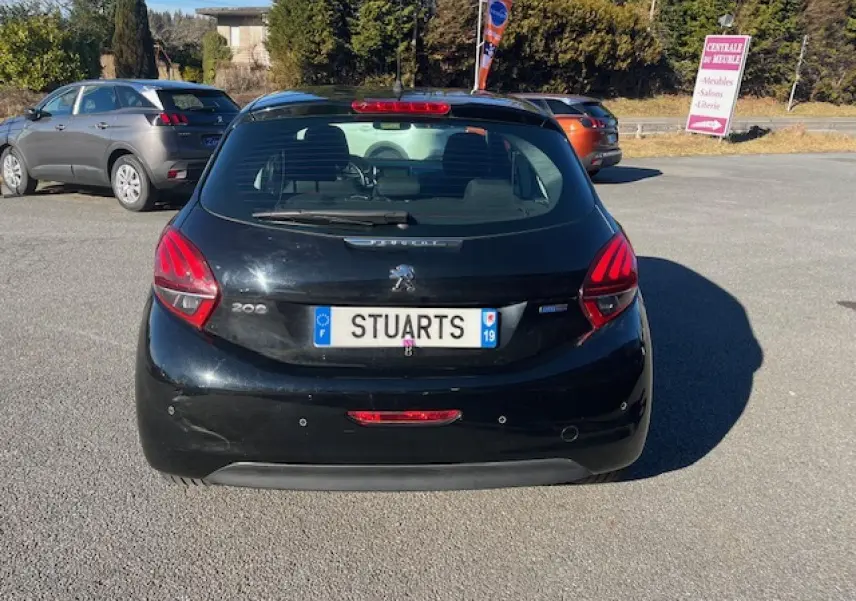 Vue arrière d'une Peugeot 208 noire 2017 avec radars de recul et plaque d'immatriculation visible en extérieur.
