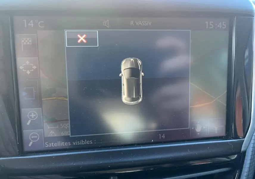 Écran tactile multifonctions de la Peugeot 208 noire, vue rapprochée du tableau de bord avec affichage de la caméra de recul.