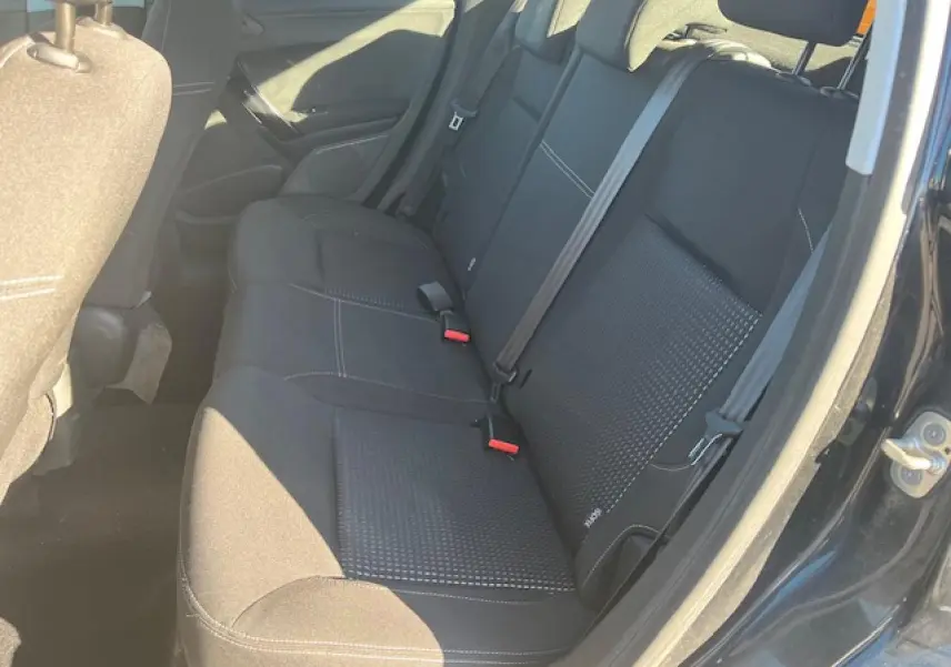 Vue intérieure côté droit montrant la banquette arrière noire de la Peugeot 208 2017 avec ceinture de sécurité et porte ouverte.