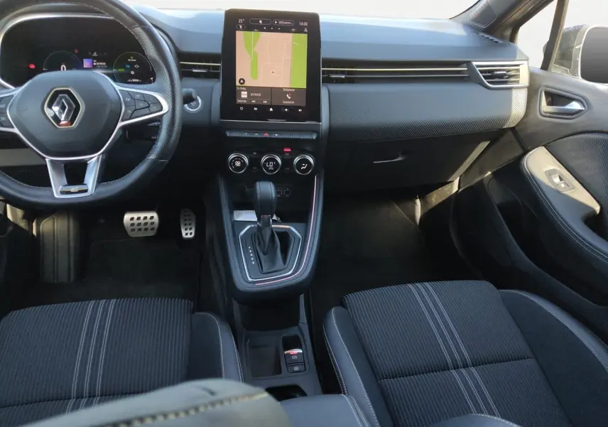 Vue intérieure avant de la Renault Clio V E-Tech, tableau de bord noir avec écran tactile central et volant multifonction.