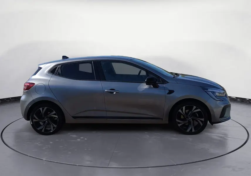 Profil droit d'une Renault Clio V E-Tech Full Hybrid 145 gris foncé métal avec jantes alliage noires et détails sportifs.