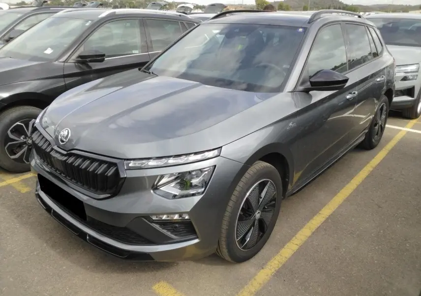 Vue 3/4 avant droite d'un Skoda Kamiq TSI 116 DSG7 Monte-Carlo gris graphite avec jantes noires et toit panoramique.