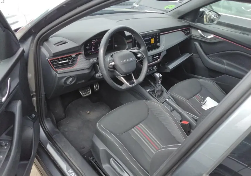 Vue intérieure côté conducteur du Skoda Kamiq gris graphite 2025, avec tableau de bord Monte-Carlo et volant cuir sport.