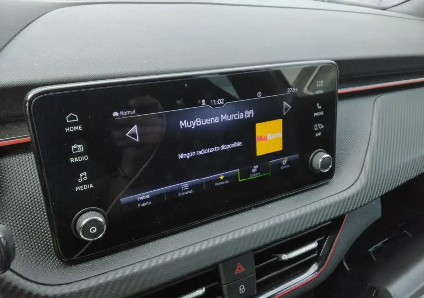 Gros plan sur l’écran central tactile du tableau de bord du Skoda Kamiq Monte-Carlo avec insert carbone et liseré rouge.