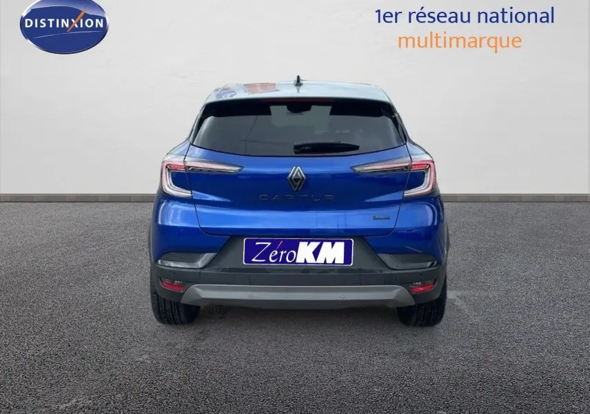 Vue arrière d'un Renault Captur bleu Iron Metal avec toit gris, version hybride 2025, sur fond neutre.