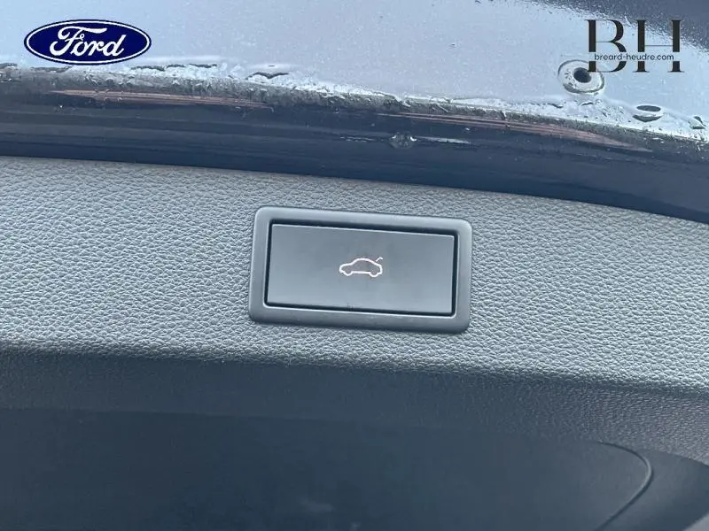 Bouton d'ouverture électrique du hayon sur le panneau intérieur noir du coffre d'un Skoda Kodiaq noir Magic Nacré.