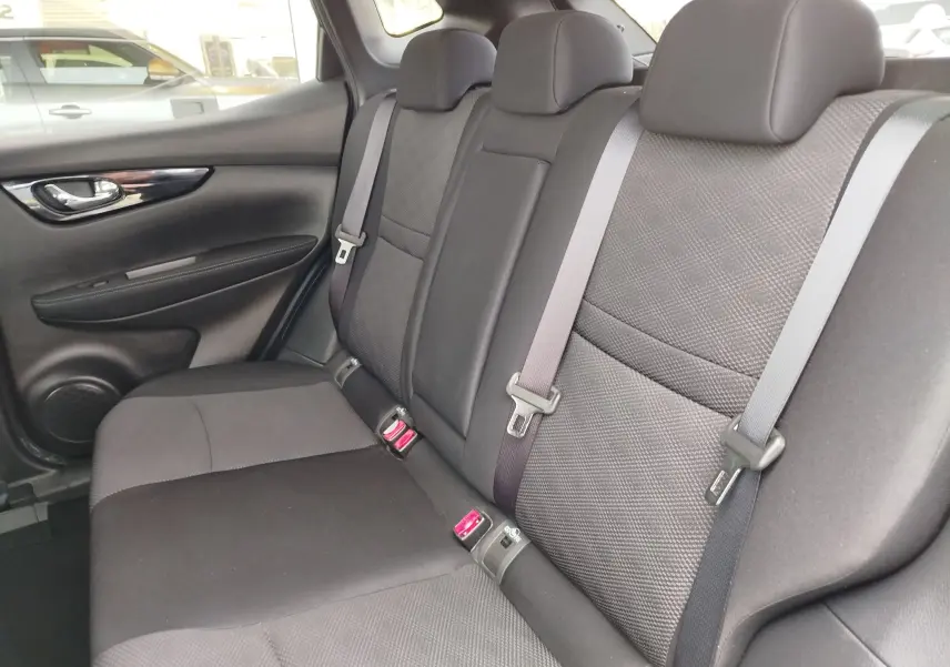 Gros plan sur la poignée intérieure chromée et les commandes des vitres côté conducteur du Nissan Qashqai bronze Ultime 2017.