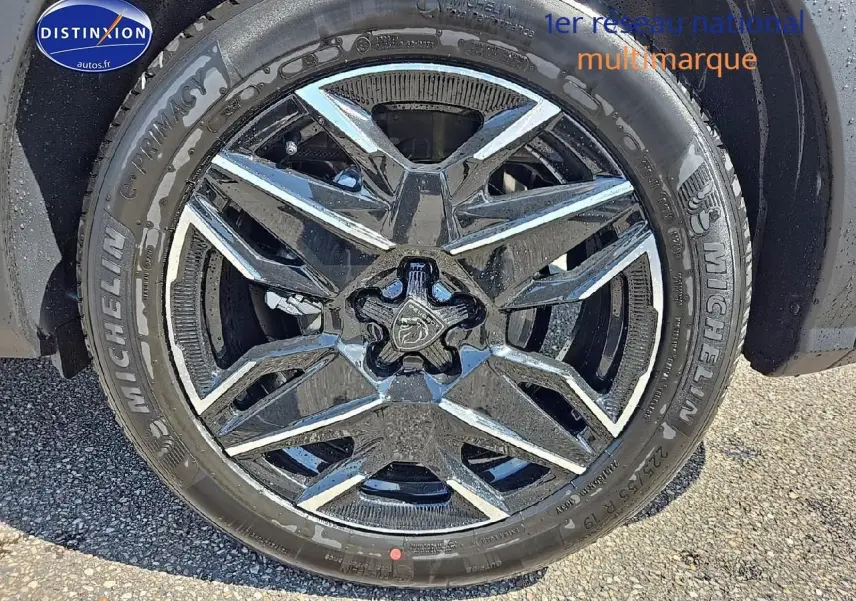 Gros plan sur la jante alu noire et chromée du côté avant droit du Peugeot 3008 noir hybride 2025.