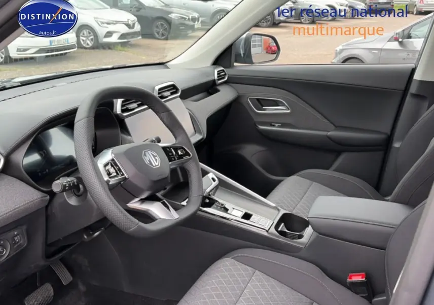 Vue intérieure côté conducteur du MG ZS Hybrid 197 gris, mettant en valeur le volant multifonction et la console centrale moderne.
