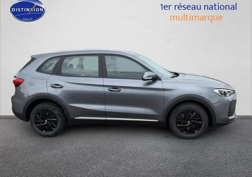 Vue de profil côté gauche du MG ZS Hybrid gris avec jantes noires et rétroviseurs argentés sur fond neutre.