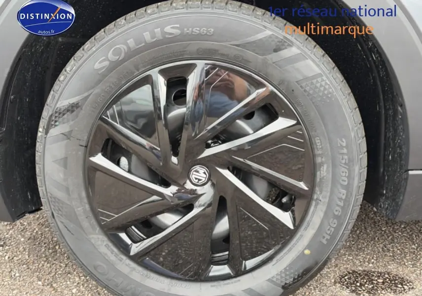 Gros plan sur la roue avant gauche du MG ZS gris 2026 avec jante acier noire et logo MG au centre.