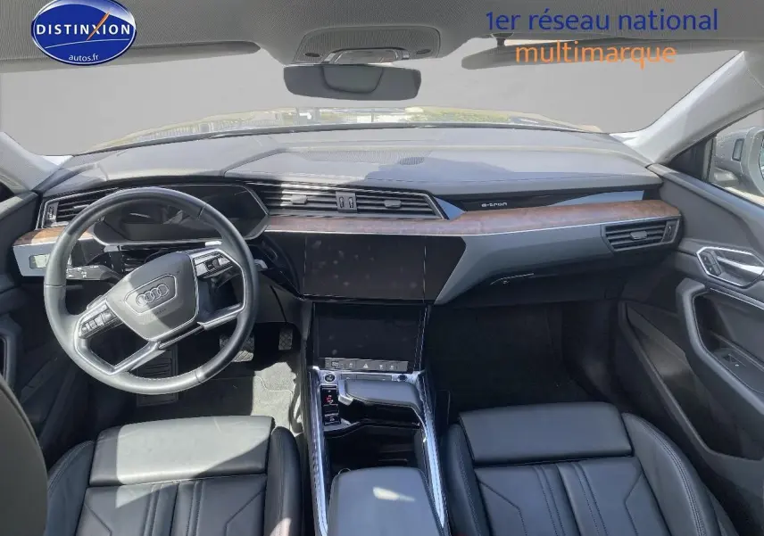 Vue intérieure avant de l'Audi Q8 E-TRON 55 408 avus quattro 2022 avec tableau de bord bois et cuir noir.