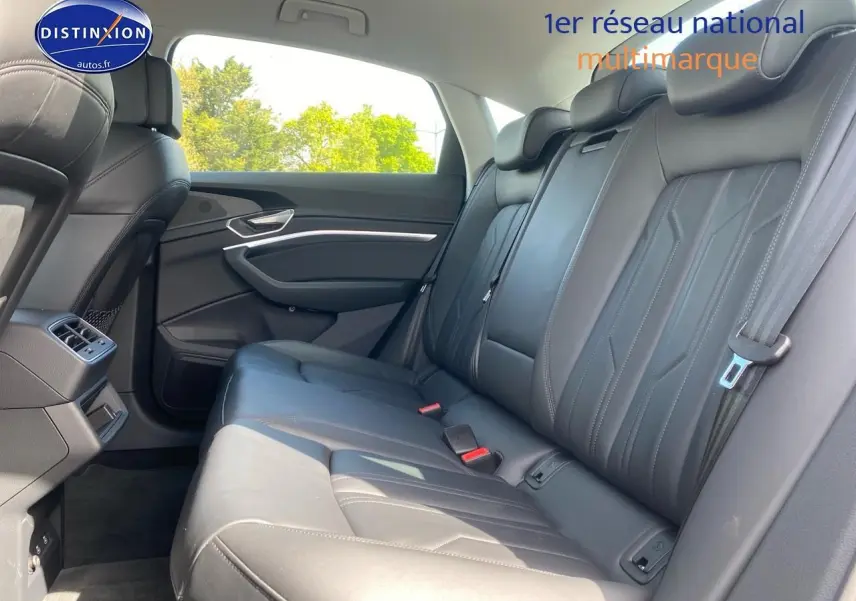 Vue latérale droite des sièges arrière en cuir noir de l'Audi Q8 E-Tron gris, avec ceintures et appuie-têtes visibles.
