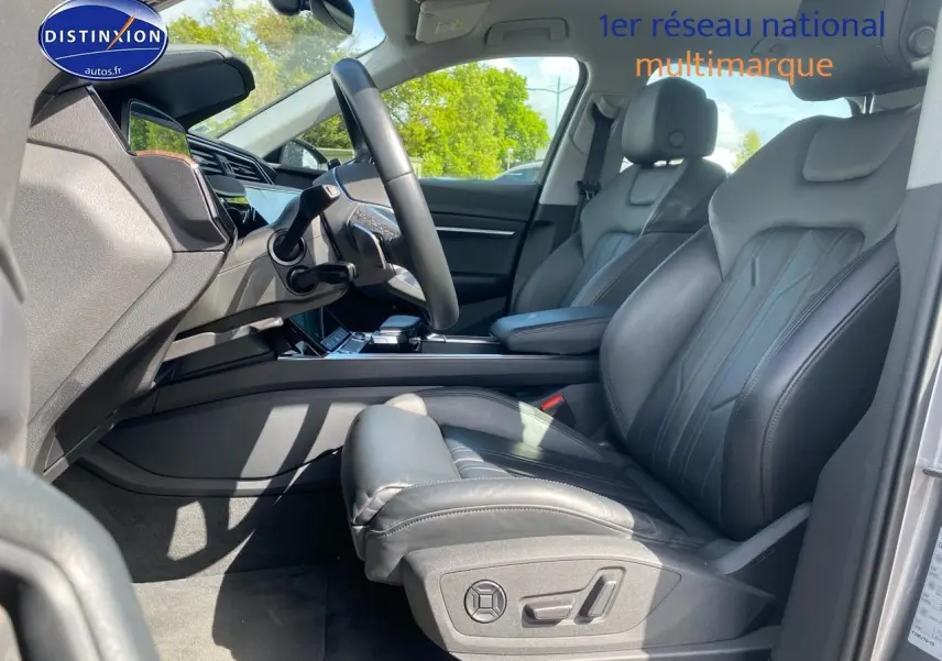 Intérieur avant droit de l’Audi Q8 E-Tron gris 2022 avec sièges sport cuir noir et tableau de bord moderne.