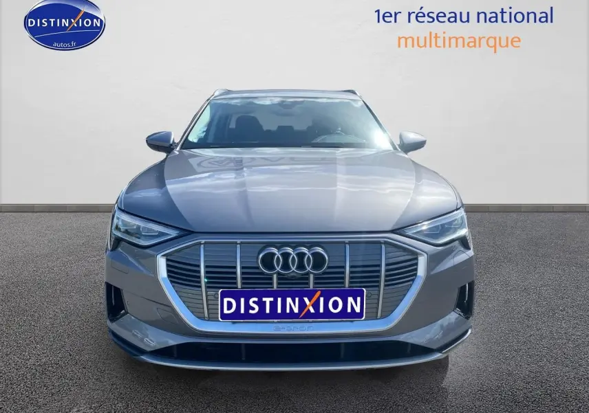 Audi Q8 E-Tron gris vue de face avec calandre large et logo Audi bien visible sur fond neutre.
