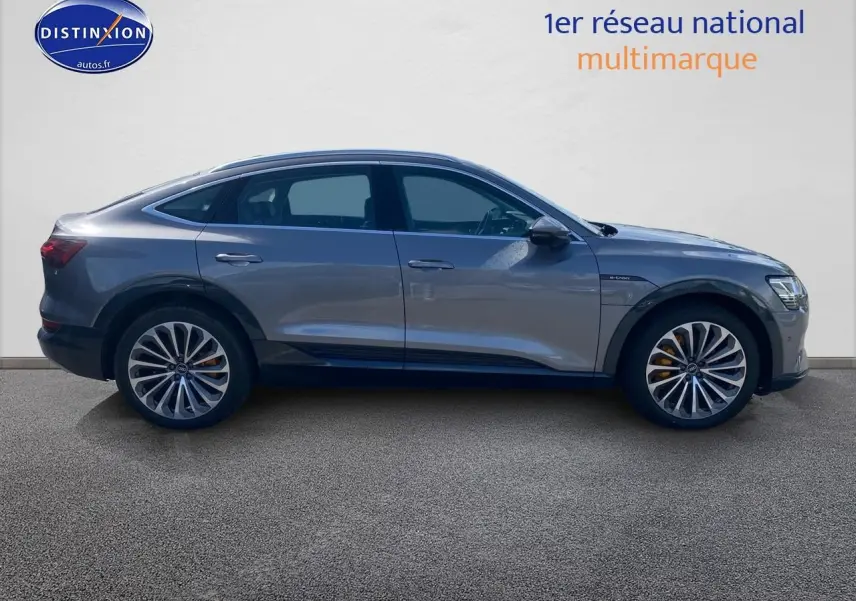 Audi Q8 E-Tron gris en vue latérale droite, soulignant ses jantes alu et sa silhouette élancée électrique.