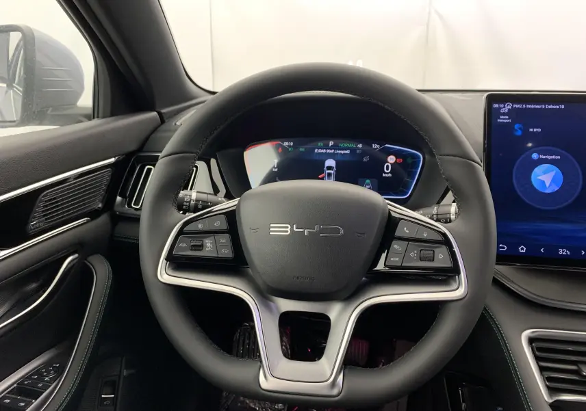 Vue intérieure centrée sur le volant noir du BYD SEAL U 2026 avec tableau de bord numérique et écran tactile latéral.