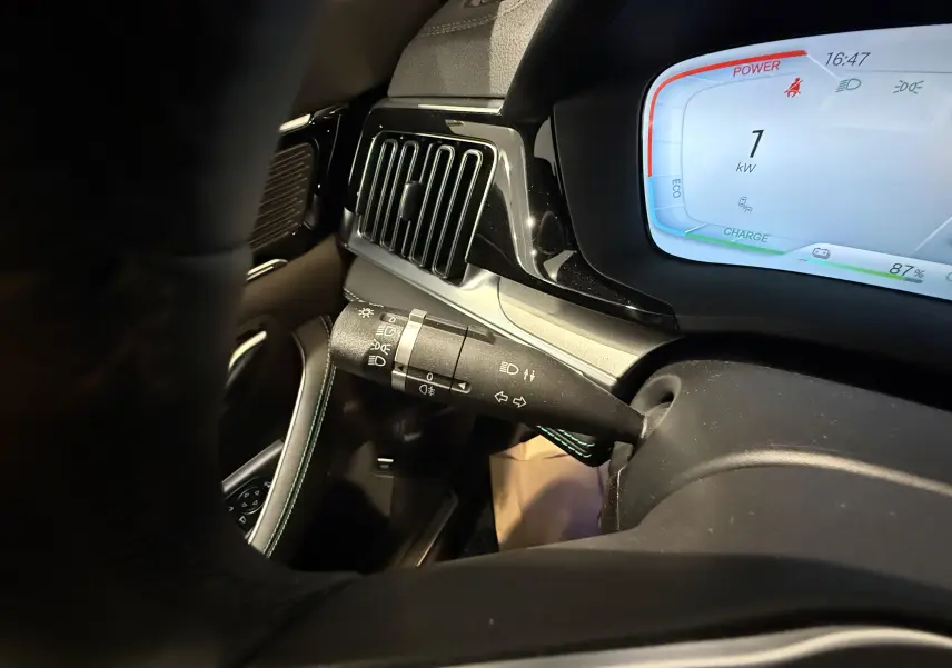 Gros plan sur la commande de clignotant et l'écran digital bleu du tableau de bord intérieur du BYD SEAL U gris.