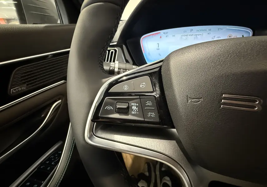 Vue rapprochée du volant noir de la BYD SEAL U 2026, montrant les commandes multifonctions côté gauche et le tableau de bord numérique.
