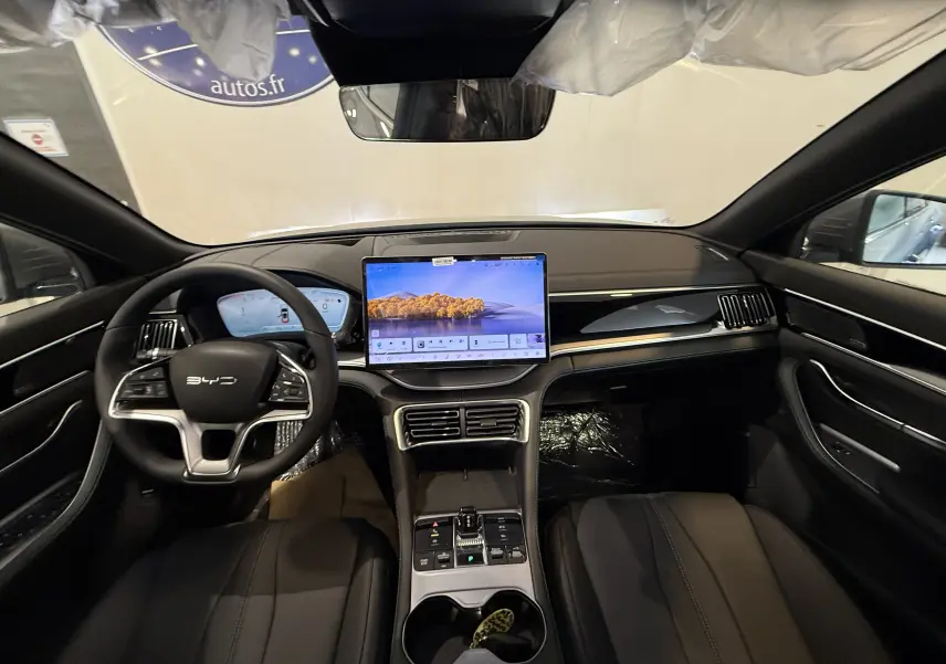 Vue intérieure avant du BYD SEAL U gris, mettant en valeur le tableau de bord numérique et l'écran tactile central.