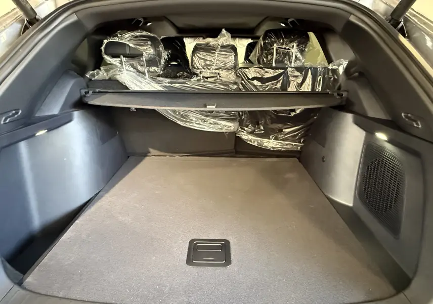 Coffre spacieux du BYD SEAL U gris vu de l'arrière, avec sièges arrière protégés par des housses plastiques.