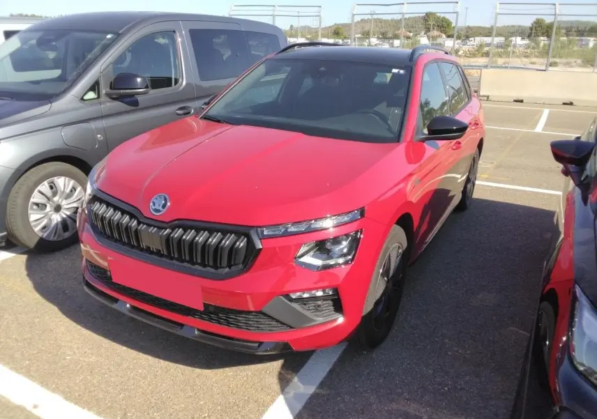 Vue 3/4 avant droite d'un Skoda Kamiq Monte-Carlo rouge Velvet avec toit panoramique et jantes alliage noires.