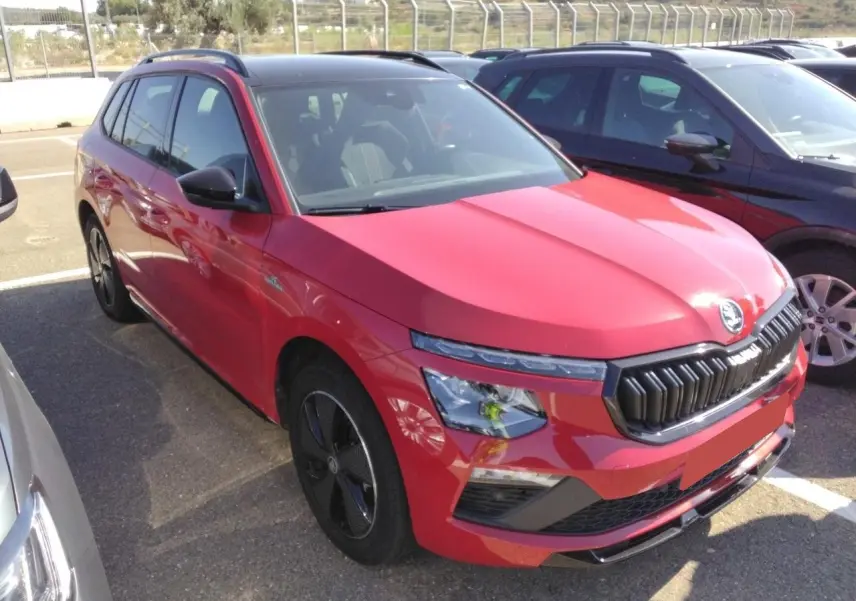 Vue 3/4 avant gauche d’un Skoda Kamiq Monte-Carlo rouge Velvet avec toit panoramique et jantes alliage noires.