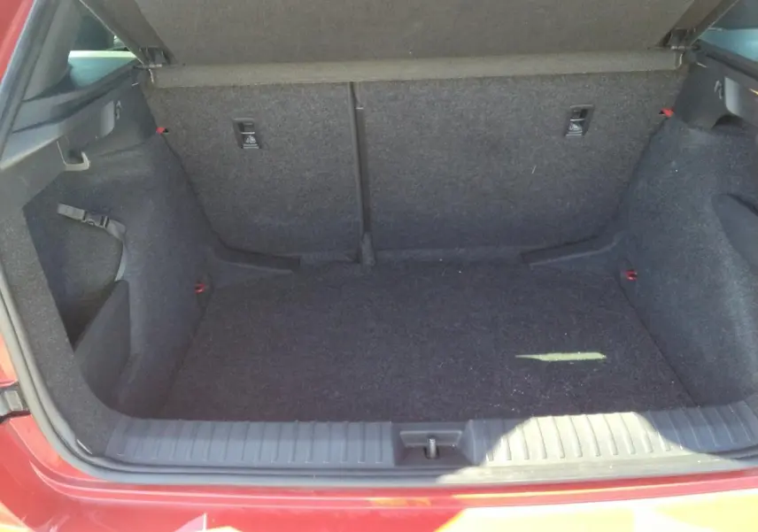Coffre ouvert d'un Skoda Kamiq Rouge Velvet, vue arrière mettant en valeur l'espace de chargement et le hayon électrique.