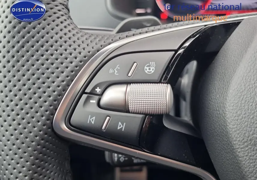 Gros plan sur les commandes multifonctions du volant cuir perforé du Skoda Karoq gris graphite 2025, version sportline.