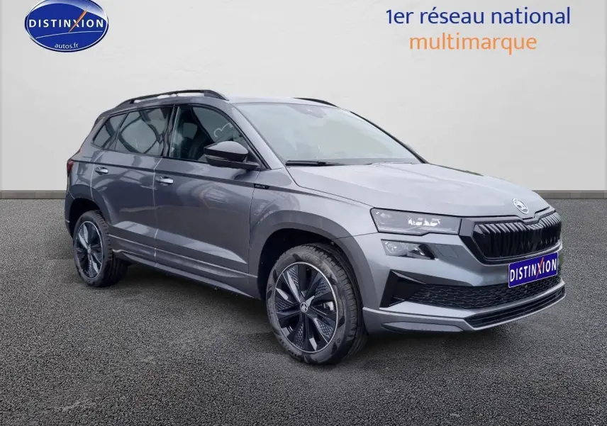 Vue 3/4 avant droite du SUV SKODA KAROQ gris graphite 2025 avec jantes alliage et calandre noire sportive.