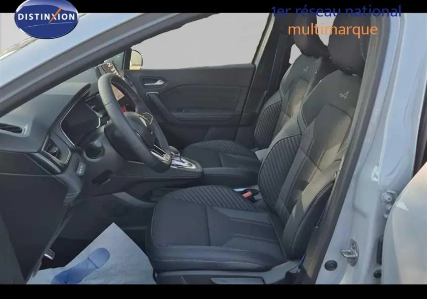 Vue intérieure côté conducteur du Renault Captur gris Rafale, sièges noirs avec surpiqûres et volant multifonction.