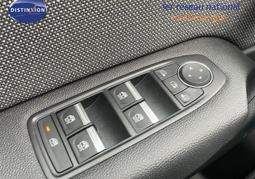 Gros plan sur les commandes de lève-vitres et rétroviseurs sur la porte côté conducteur du Renault Captur gris Rafale 2025.