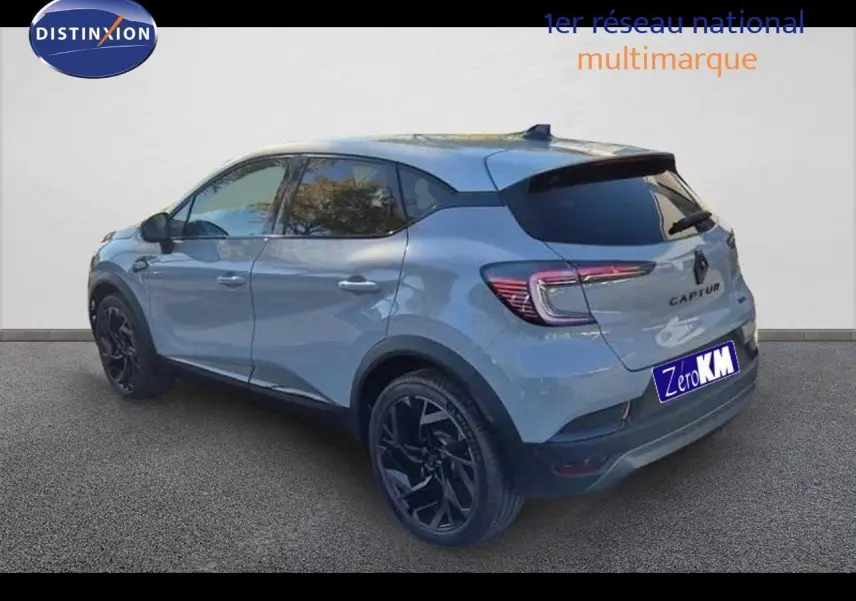 Renault Captur E-Tech hybride gris Rafale en 3/4 arrière côté gauche avec jantes noires et toit gris.