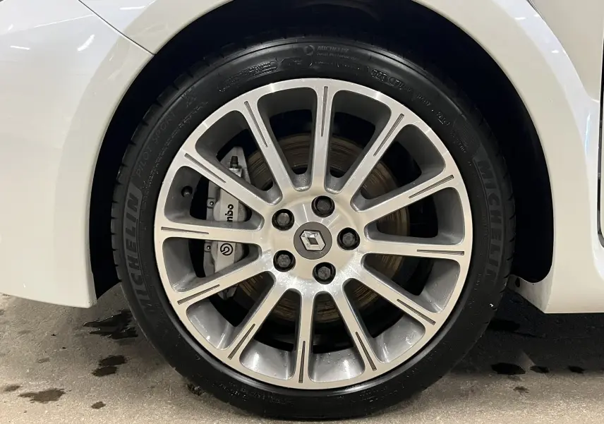 Gros plan sur la jante alliage 17 pouces et le frein Brembo de la Renault Clio III RS 20th Anniversary blanc nacré.