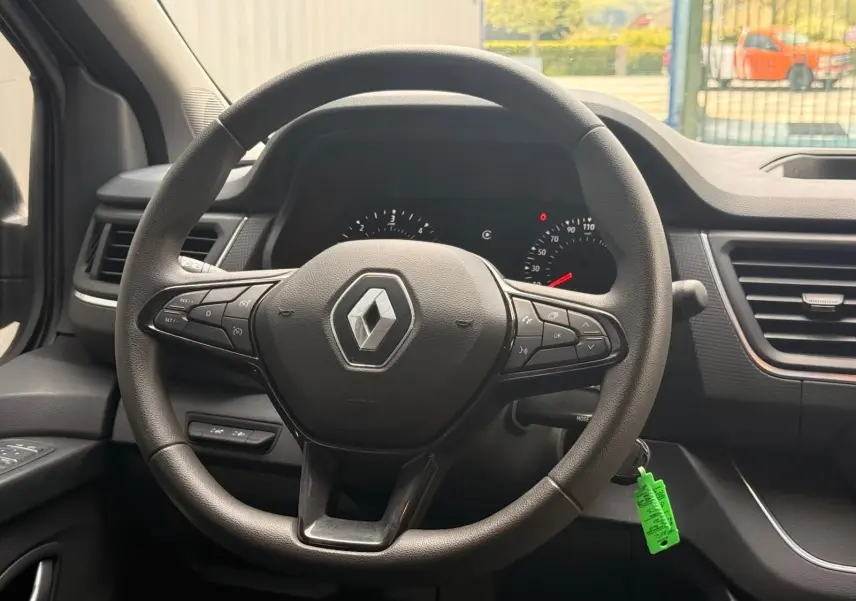 Vue rapprochée du volant noir du Renault Trafic cabine approfondie 2024 avec tableau de bord et commandes intégrées.