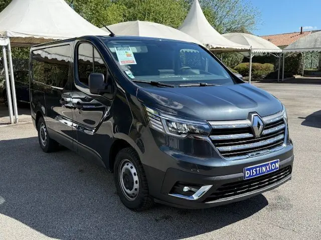 Renault Trafic Cabine Approfondie gris comète, vue 3/4 avant droit, avec calandre chromée et vitres latérales teintées.