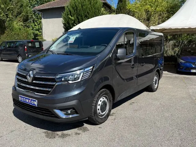 Vue 3/4 avant droite d'un Renault Trafic Cabine Approfondie gris comète avec portes latérales vitrées et jantes acier.