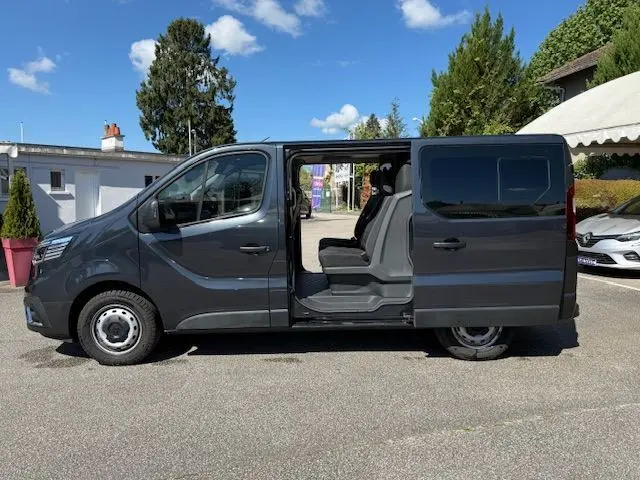 Vue latérale droite du Renault Trafic Cabine Approfondie gris comète avec porte coulissante ouverte révélant l'intérieur à six places.